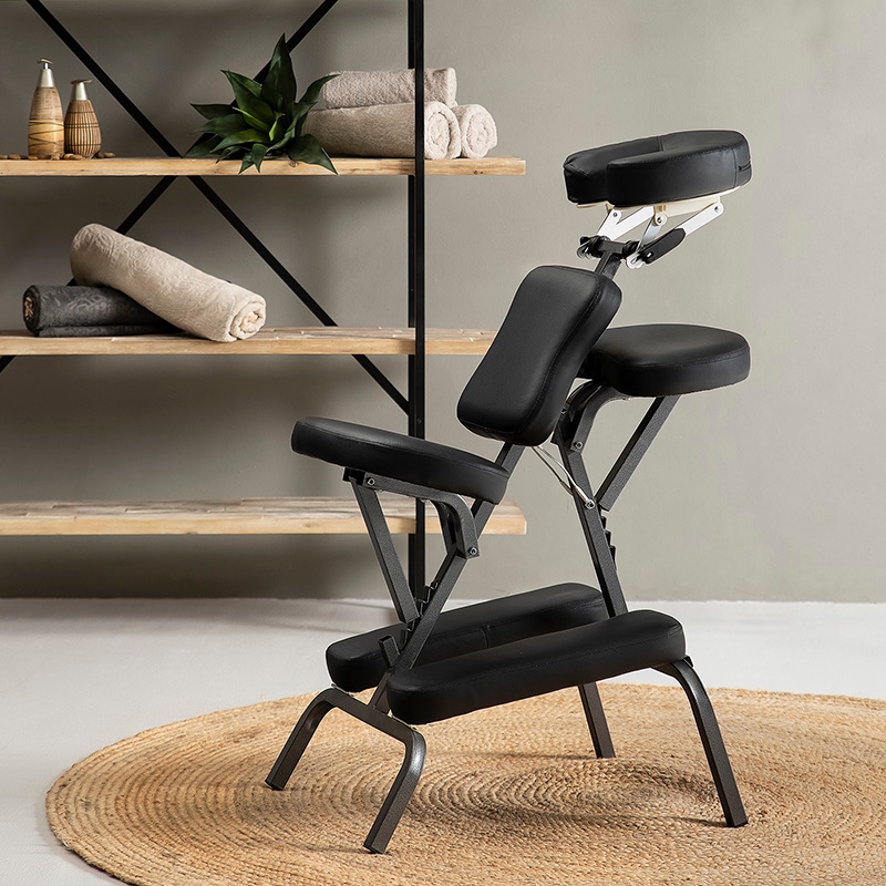 Black portable massage chair in a professional therapy setting